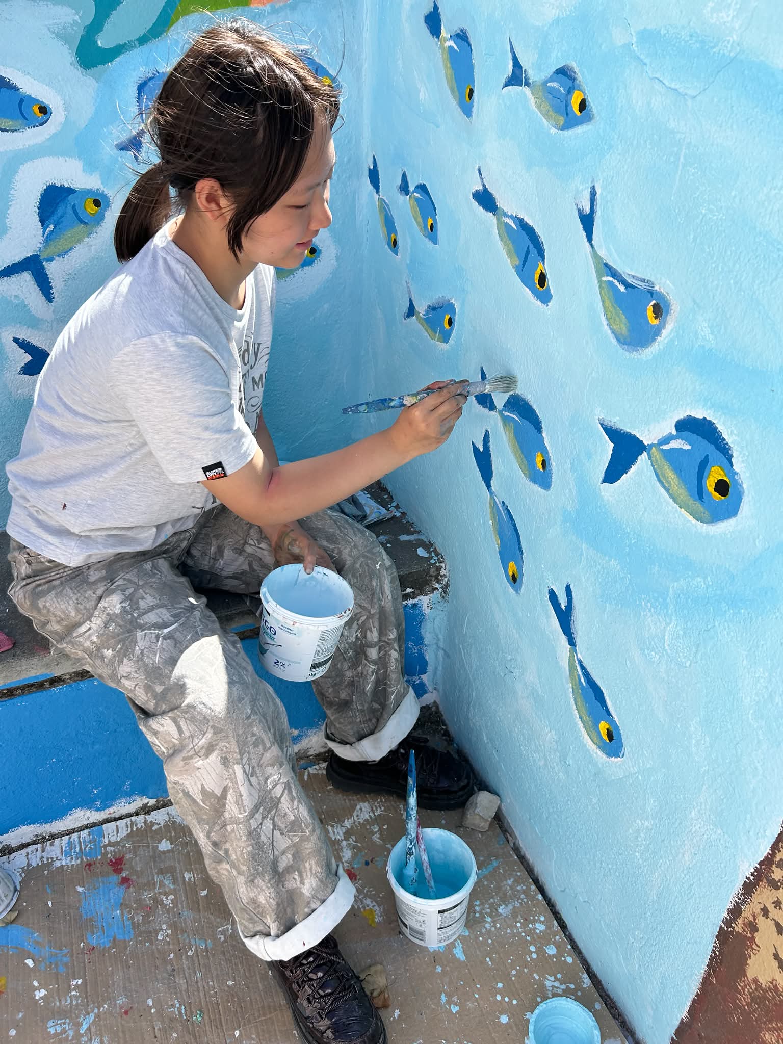 Pintura dos cardumes de peixes, que fogem da poluição, realizada pela autora do desenho vencedor, selecionado por toda a comunidade escolar.