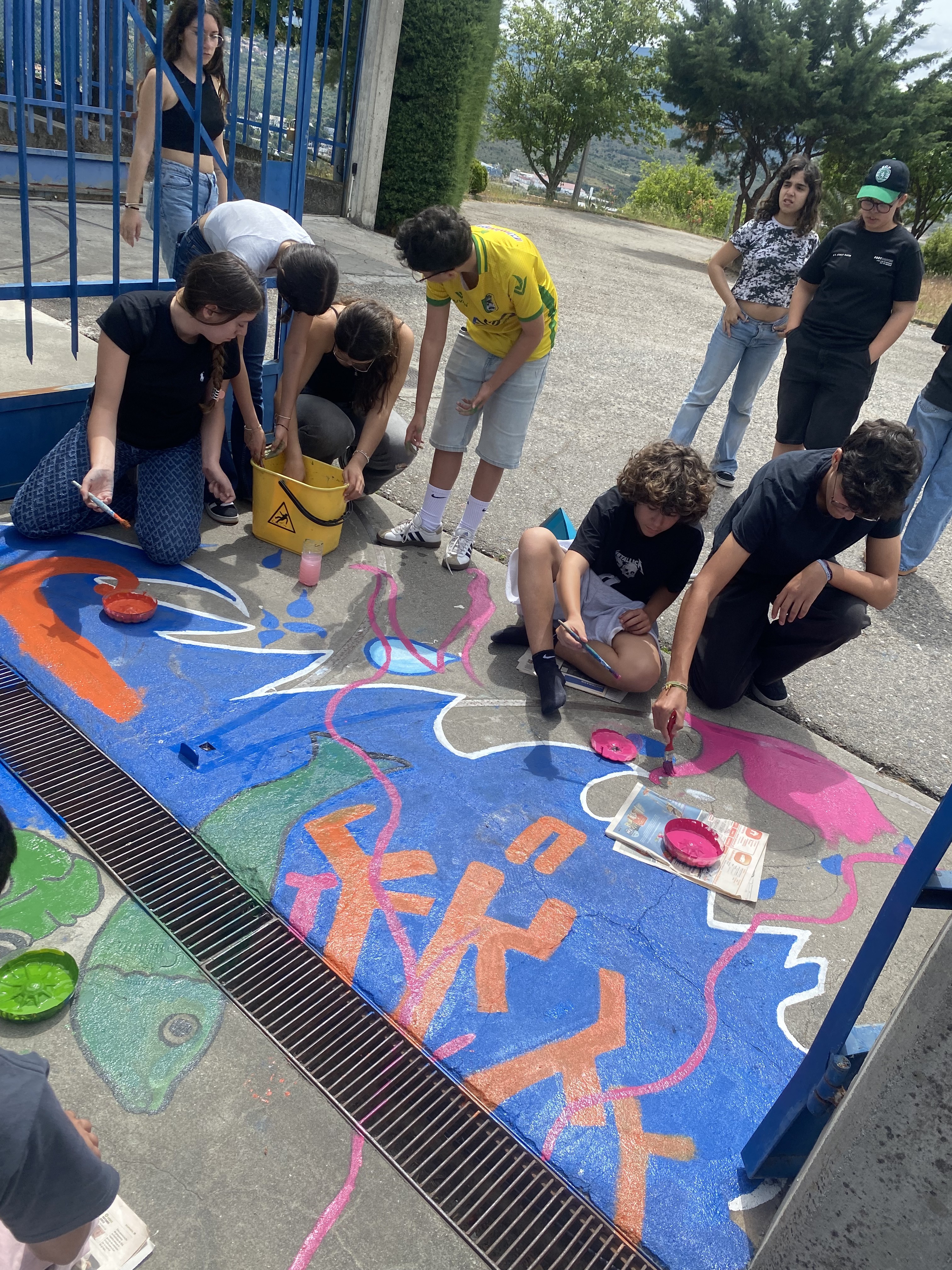 A pintura foi realizada pelos alunos, organizados em pequenos grupos de trabalho, que participaram nas diversas fases do processo: preparação do espaço, marcação do desenho, pintura e acabamentos. Foram utilizadas tintas adequadas para pavimentos exteriores, privilegiando cores vivas e apelativas que captam a atenção de quem entra na escola.
