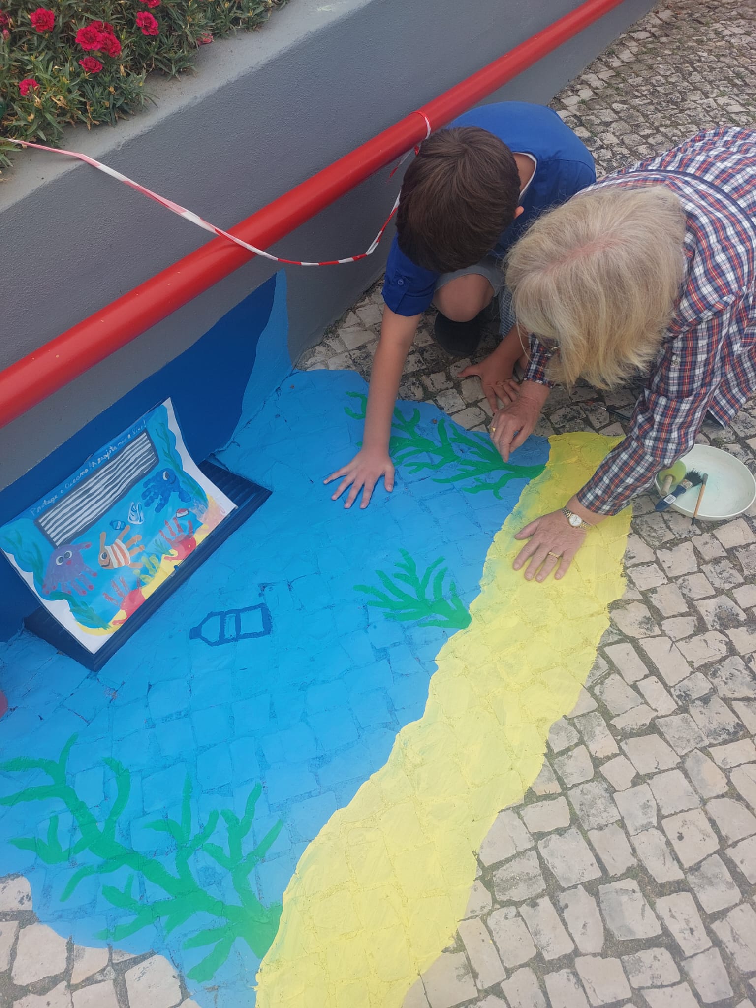 Aluno a estampar a mão para fazer de peixes