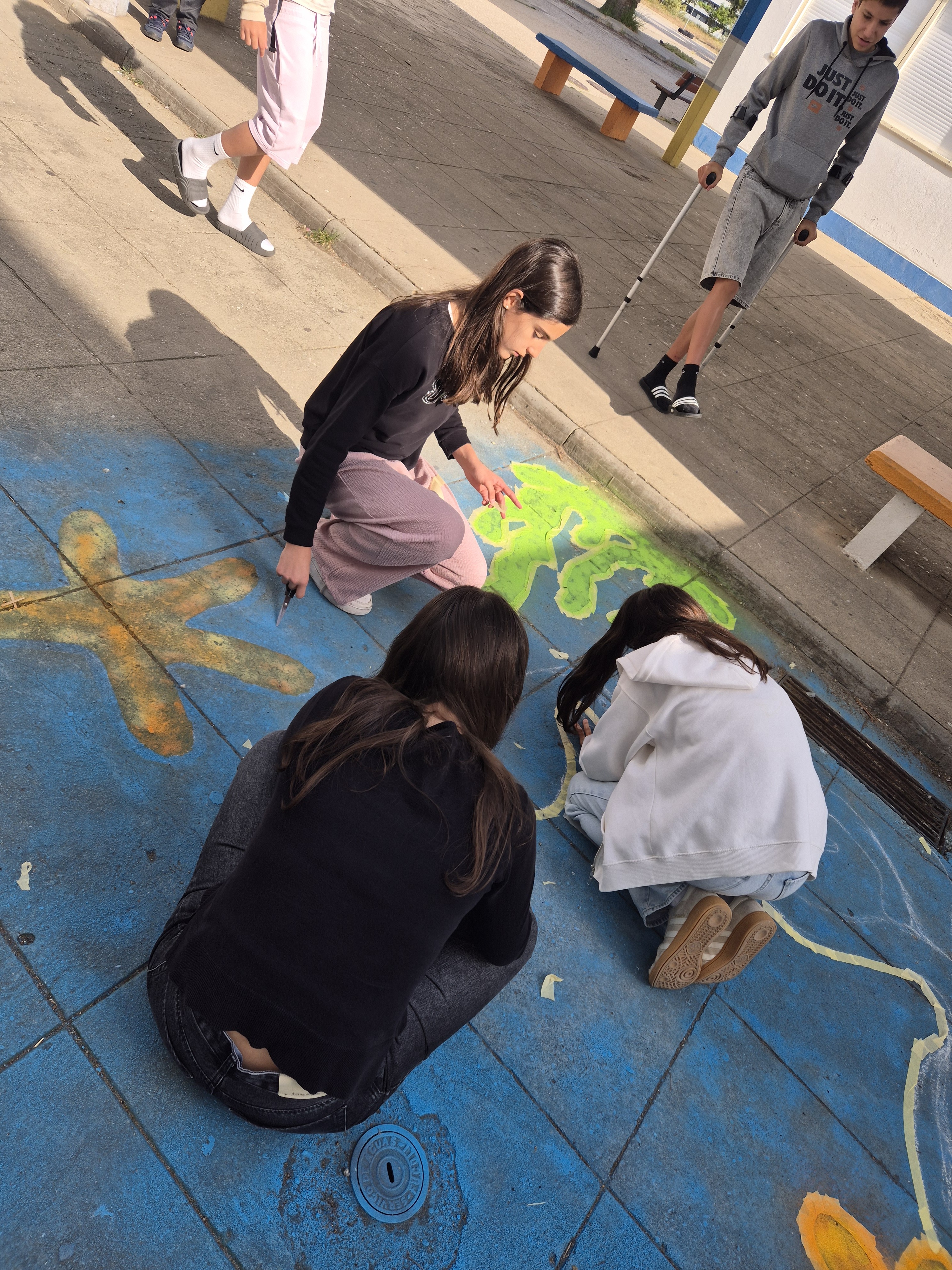 Trabalho no pátio da escola<br />
Momento de execução da pintura no pavimento, com participação dos alunos na construção coletiva da composição.